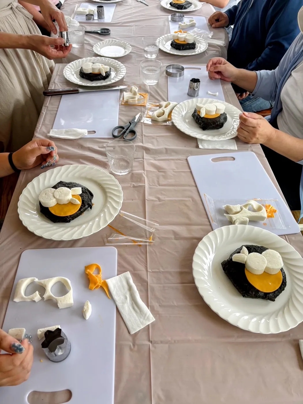 テーブルを囲み、それぞれの手でお皿の料理を飾りつけている様子