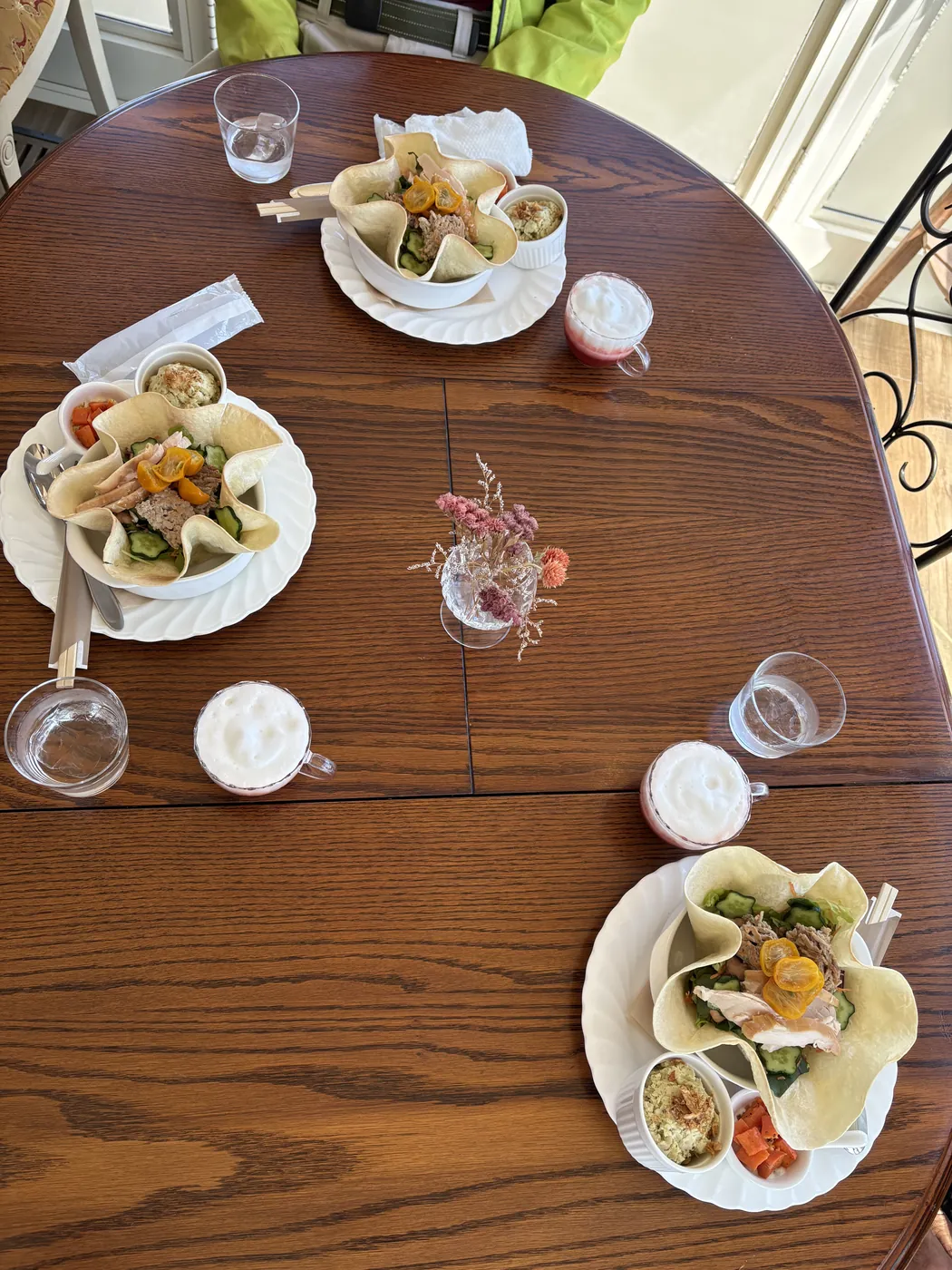 丸いテーブルに並んだ料理とグラス